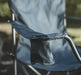 Outwell Spruce Folding Camping Chair - Fjord Blue - lifestyle image, showing chair outdoors, with close-up on armrest drinks holder