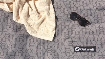 Outwell Winwood 8 Tent Carpet main feature image of carpet pattern with towel and sunglasses on it