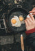 Robens Tahoe Pan lifestyle image an egg being cracked into pan