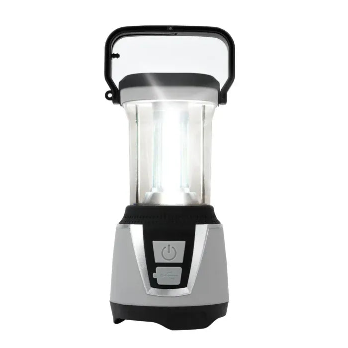 Storm Preparation Kit Bundle 1 – product image, showing a portable LED camping lantern with a silver and black base, a clear body, and a black carrying handle, shown illuminated against a white background.