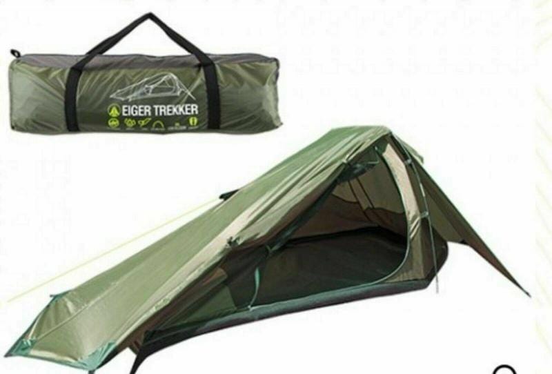 Green camping tent with carrying bag on a white background