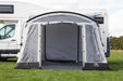 Sunncamp Swift 325 Tall Motorhome Porch Awning feature image of the awning pitch in a field on the side of a motorhome with trees in the background.  front view of the awning with front door rolled up. back to to vehicle zipped shut