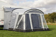 Sunncamp Swift 325 Tall Motorhome Porch Awning feature image of the awning pitch in a field on the side of a motorhome with trees in the background.  all curtains rolled up and all doors zipped shut
