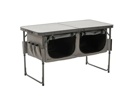 Travellife Toledo Wide Folding Camping Storage Unit – main product image, showing a grey folding camp table with two large black storage bins underneath and side utility pockets, shown on a plain white background.