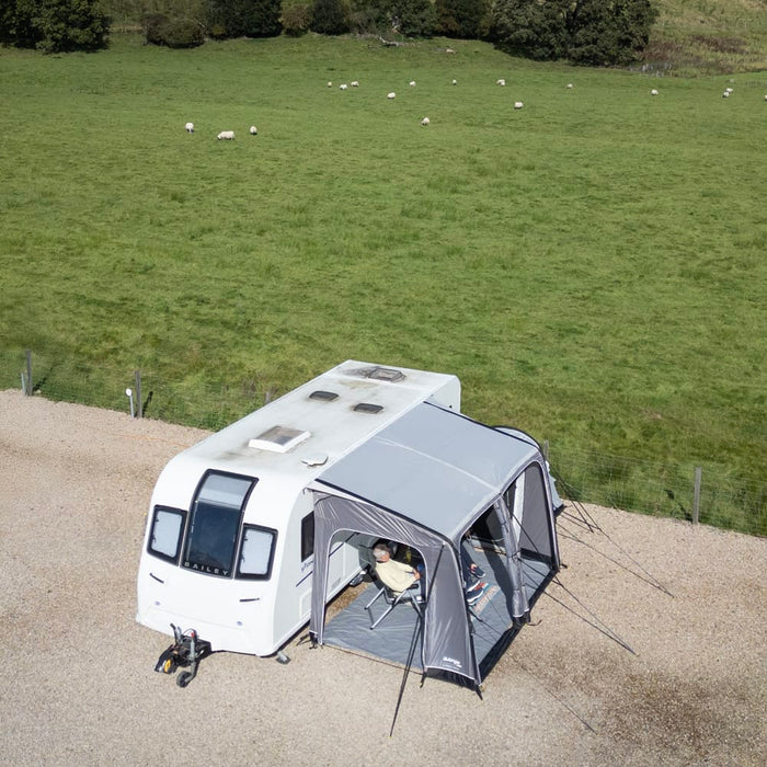 Vango Balletto Air 390 Inflatable Caravan Porch Awning - 2026 Model - lifestyle image, showing couple inside awning attached to caravan from bird's eye view