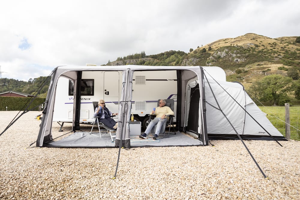 Vango Balletto Air 390 Inflatable Caravan Porch Awning - 2026 Model - lifestyle image, showing couple inside awning attached to caravan