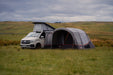 Vango Cove Air TC Inflatable Drive Away Awning Grey - Low lifestyle image of awning pitched in field with hills behind. view shows into front canopy with all doors zipped up. 