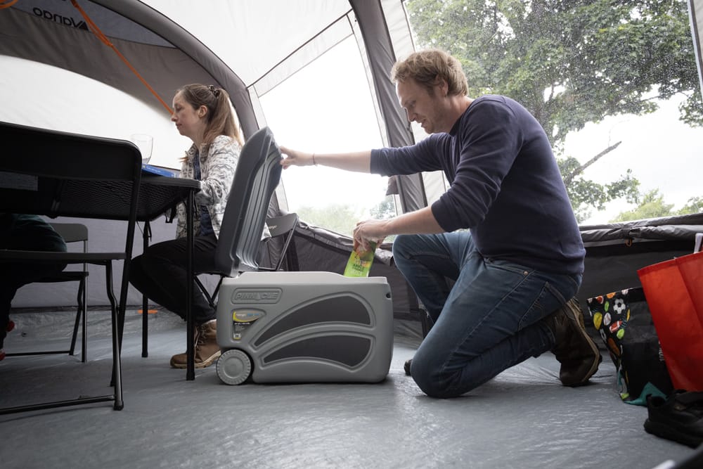 Vango Pinnacle 45L 100 Hours Wheelie Camping Cool Box - lifestyle image, showing couple in tent using cool box