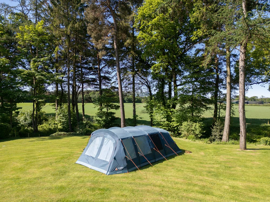 Vango Savannah 600XL 6-Person Family Tent Package - lifestyle image, showing tent pitched in field with surrounding trees