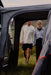 Vango Versos Air Inflatable Cloud Grey Drive Away Awning - Low lifestyle feature image of a couple walking into the tunnel from the rear of the vehicle with both doors unzipped