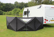 Outdoor Revolution Pronto Compact 3 Panel Pop up Windbreak Shown next to a caravan